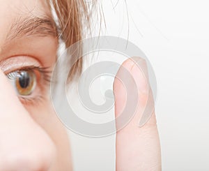 Woman inserts contact lens in eye