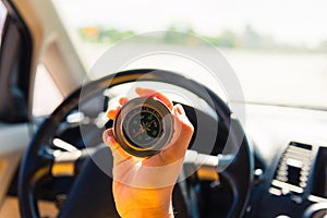 Woman inside a car and using compass to navigate while driving the car