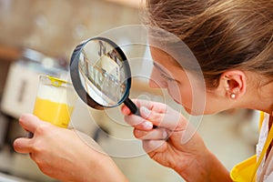 Woman inspecting food with magnifying glass.