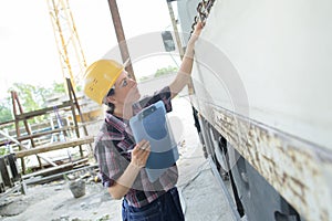 woman inspecting side truck