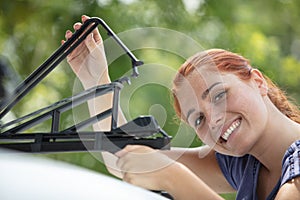 woman install bicycle rake on roof car