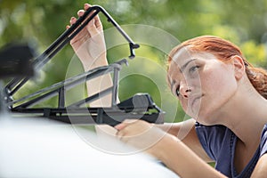 woman installing car roof cargo