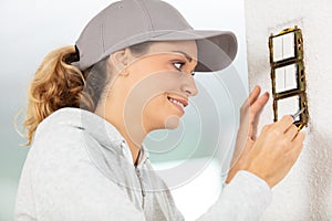 Woman installing electrical switches checking fastening screws