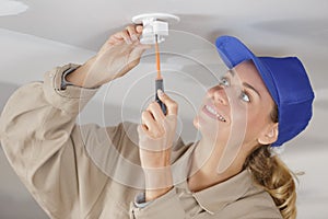 Woman installing light fitting