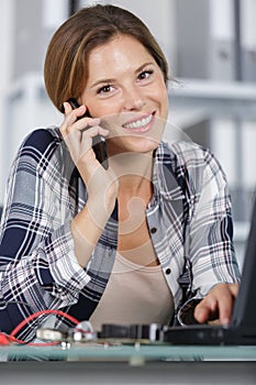 woman installing new app on laptop computer making mobile phone-call