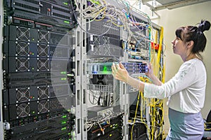 A woman installs a new server in a modern data center.Girl system administrator works with powerful computer equipment. Hosting