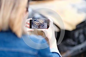 Woman insurance broker making photo of burnt car