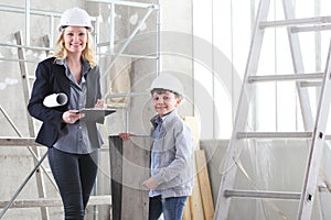 Woman interior designer or architect mom with her son at work, they choose how to furnish the house, inside the construction site