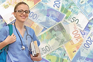 Woman intern doctor with stethoscope and books on the background of the money Israel shekel bills. Medical education concept