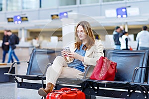 Woman at international airport, reading ebook