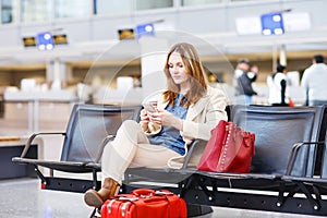 Woman at international airport waiting for flight at terminal