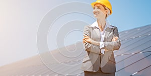 Woman investor in clean energy standing in front of solar panels