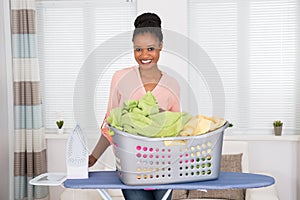 Woman With Iron And Clothes In Basket