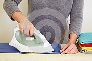 Woman ironing blue polo shirt