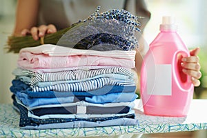 Woman with ironing board, clothes, softener and lavender