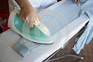 Woman ironing shirt on ironing board