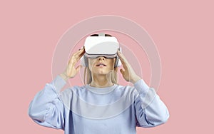 Woman isolated on color background experiencing virtual reality in innovative VR goggles