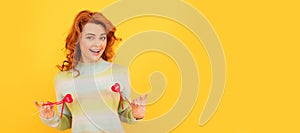 Woman isolated face portrait, banner with copy space. happy cheerful redhead girl with red heart sticks on yellow