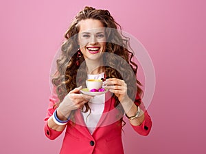 Woman isolated on pink with cup of coffee and chocolate candies