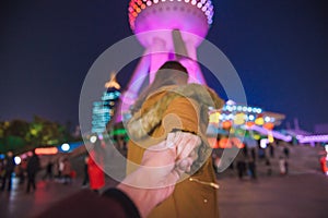Woman in jacket clothes leading man to oriental pearl tower in shanghai