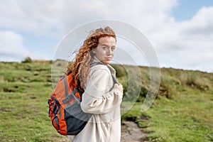 Woman in jacket reaching the destination and taking selfie and shouting on the top of mountain at sunset. Travel Lifestyle