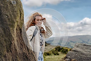 Woman in jacket reaching the destination and taking selfie and shouting on the top of mountain at sunset. Travel Lifestyle