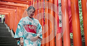 Woman, Japan and walking in kimono or traditional visit to Fushimi Inari, shrine in Kyoto. Female person, temple clothes