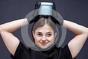 Woman with a jar of cosmetics on her head