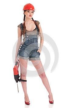 Woman in jeans coverall holding perforator drill