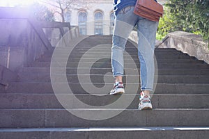 Woman in jeans going up steep stairs