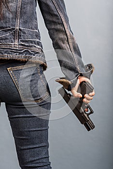 Woman in jeans is holding a gun