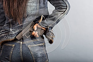 Woman in jeans is holding a gun