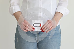 Woman in jeans and shirt shows discharged battery cell image