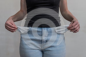 Woman in jeans twists empty pockets