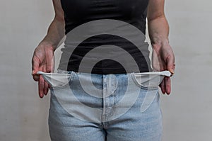 Woman in jeans twists empty pockets