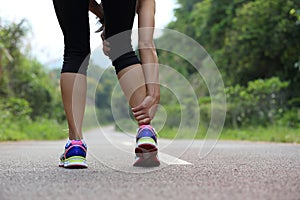 Woman jogger hold her sports injured leg