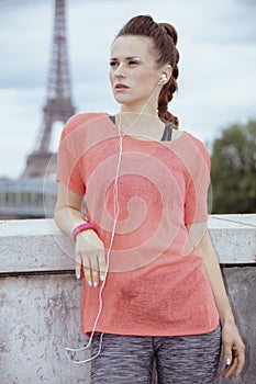 Woman jogger looking into distance and listening to the music