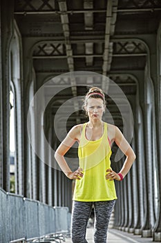 Woman jogger standing on Pont de Bir-Hakeim bridge in Paris