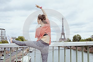 Woman jogger stretching against Eiffel tower in Paris, France