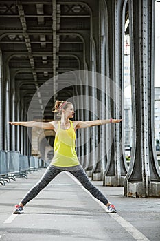 Woman jogger stretching on Pont de Bir-Hakeim bridge in Paris