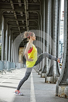 Woman jogger stretching on Pont de Bir-Hakeim bridge in Paris