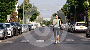 Woman jogging along a street in the morning in Israeli city