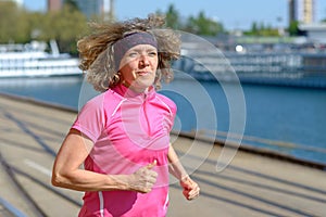 Woman jogging alongside an urban canal or river