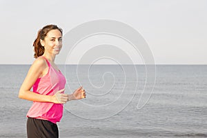 Woman jogging by beach with copy space