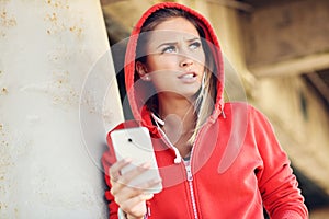 Woman jogging on the beach with smartphone