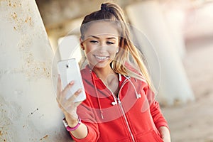 Woman jogging on the beach with smartphone