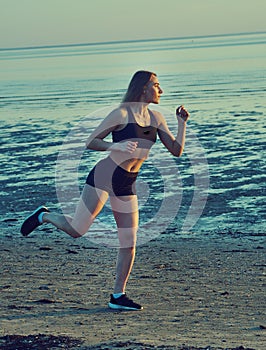 Woman jogging at evening beach