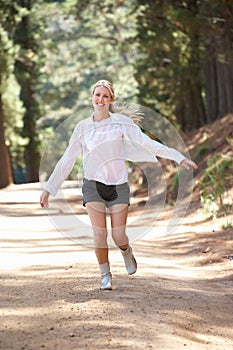 Woman jogging happily along a country lane