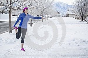 Woman jogging and stretching outdoors before a cold winter run