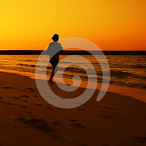 Woman jogging during Sunset over Jumeira beach in Dubai.